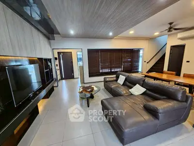 Modern living room with sleek design, leather sofa, and large TV for ultimate comfort and style.
