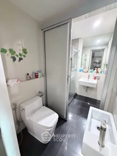 Modern bathroom with sleek fixtures and sliding door for privacy