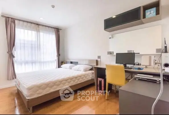 Modern bedroom with study area, featuring sleek furniture and natural light.