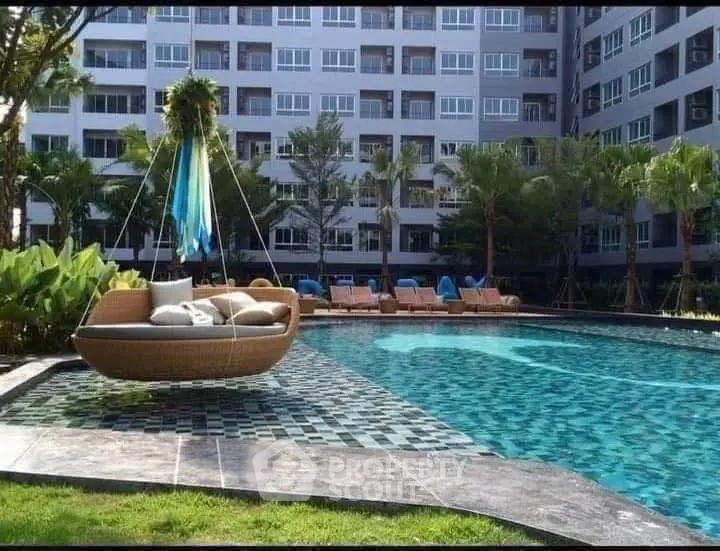 Luxurious apartment complex with stunning pool and modern outdoor seating area.