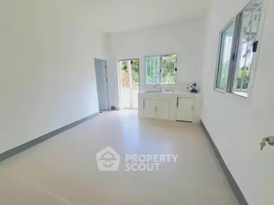 Bright and spacious kitchen with white cabinetry and large windows