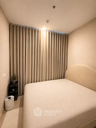 Cozy bedroom with elegant curtains and modern decor, perfect for relaxation.