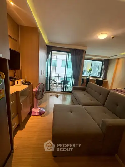 Modern living room with cozy sectional sofa and balcony view in stylish apartment