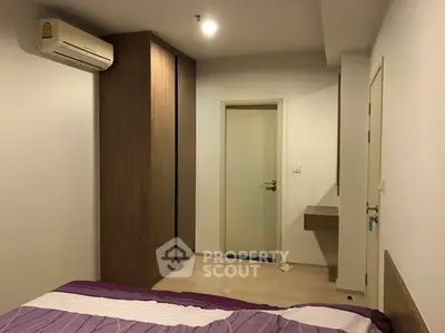 Modern bedroom with air conditioning and wooden wardrobe in a cozy apartment.