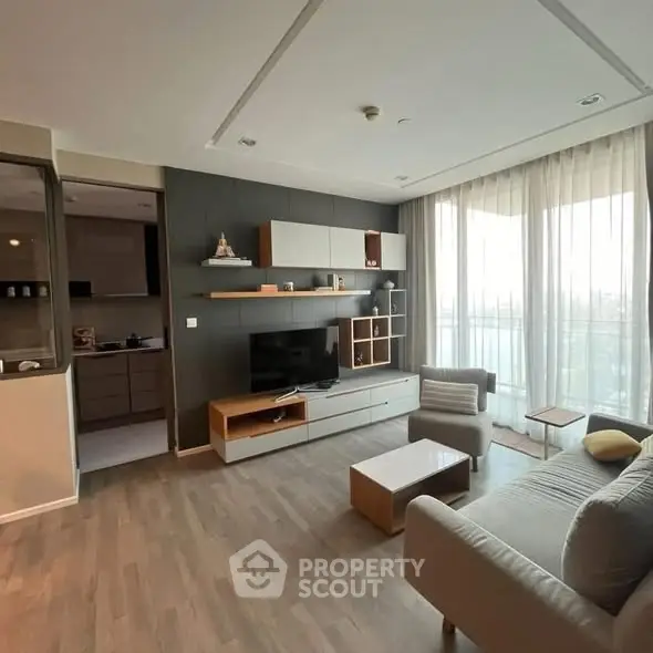 Modern living room with stylish furniture and large windows offering natural light and a cozy atmosphere.
