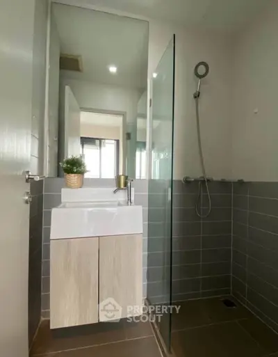 Modern bathroom with sleek design and glass shower enclosure in a stylish apartment.