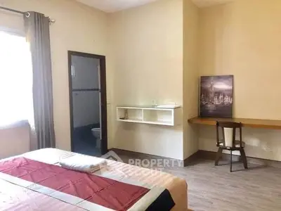 Spacious bedroom with modern decor and attached bathroom, ideal for comfortable living.