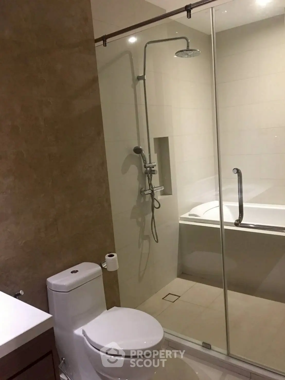 Modern bathroom with glass shower and bathtub in elegant design.