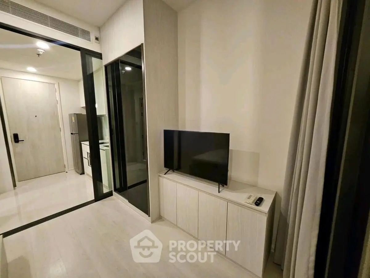 Modern living room with sleek TV setup and minimalist decor in a stylish apartment.