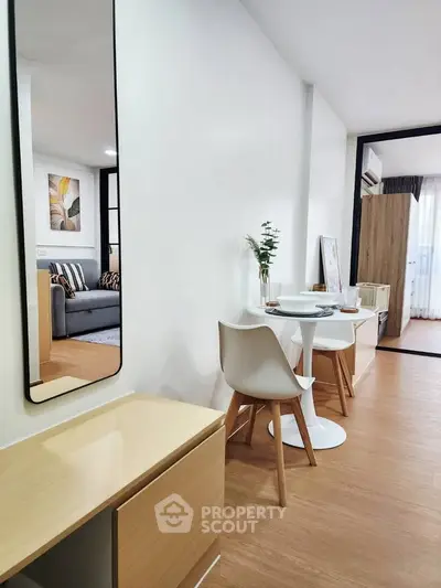 Modern apartment interior with stylish dining area and cozy living room, featuring elegant decor and natural light.