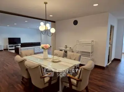 Spacious dining area with elegant lighting and cozy seating in modern open-plan living space.