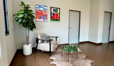 Modern living room with stylish armchair, vibrant artwork, and indoor plant.