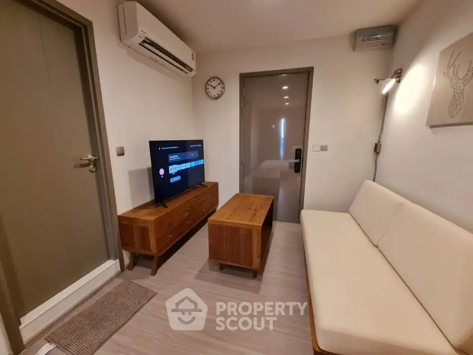 Cozy living room with modern furniture and wall-mounted TV, perfect for relaxation.