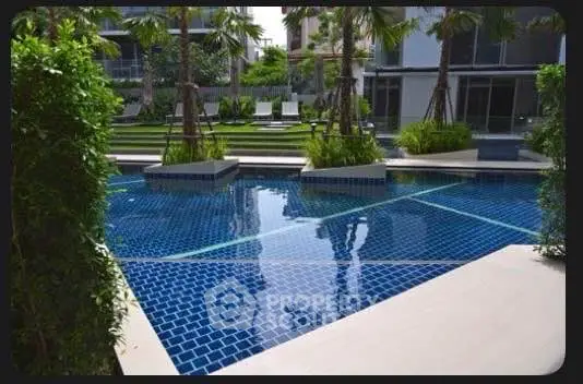 Luxurious residential pool area with lush greenery and modern design.