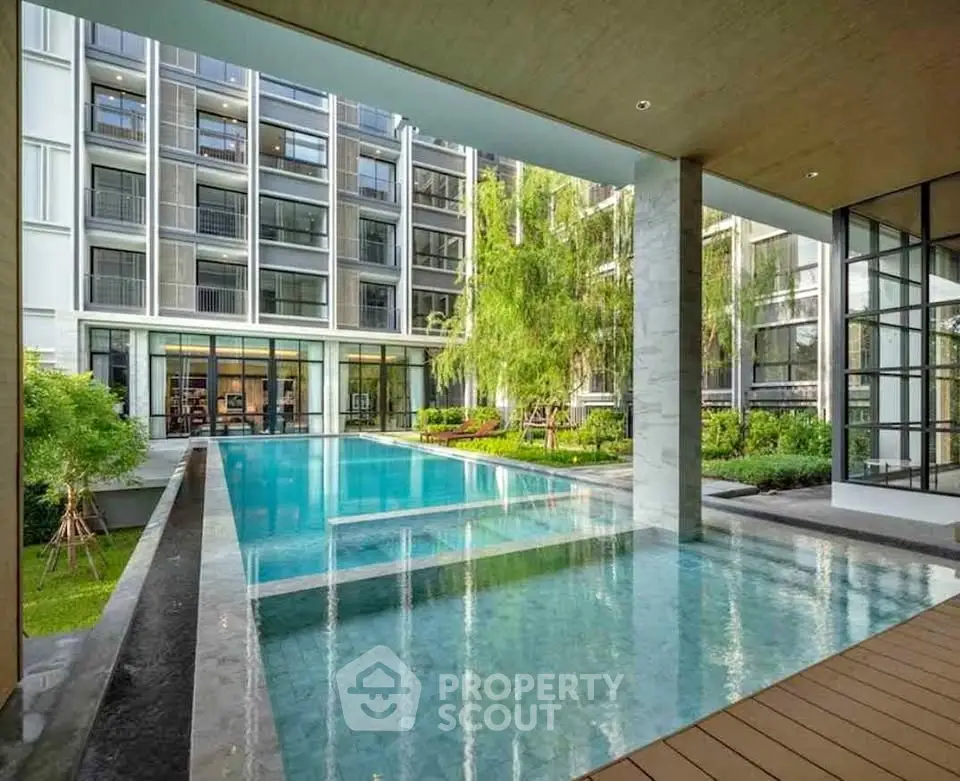 Luxurious modern apartment complex with stunning pool and lush greenery