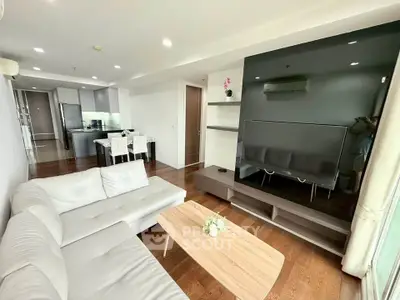 Spacious modern living room with sleek furniture and open kitchen layout