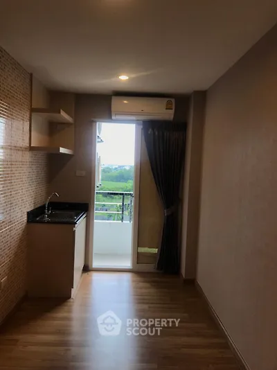 Compact kitchen with balcony view in modern apartment