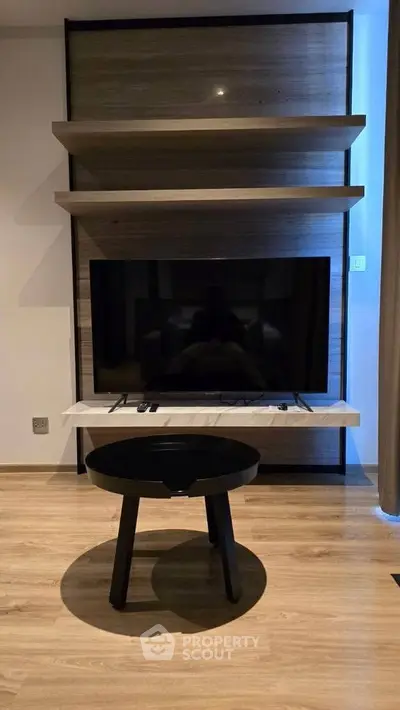 Modern living room with sleek TV setup and stylish wooden shelves