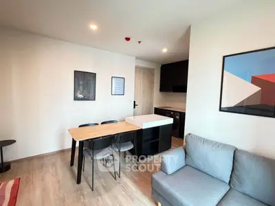 Modern living room with dining area and compact kitchen in open layout apartment.