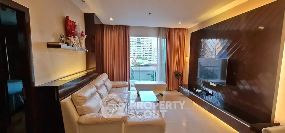 Luxurious living room with modern decor and city view balcony, featuring elegant lighting and plush seating.