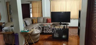 Cozy living room with sectional sofa and TV, perfect for relaxation.