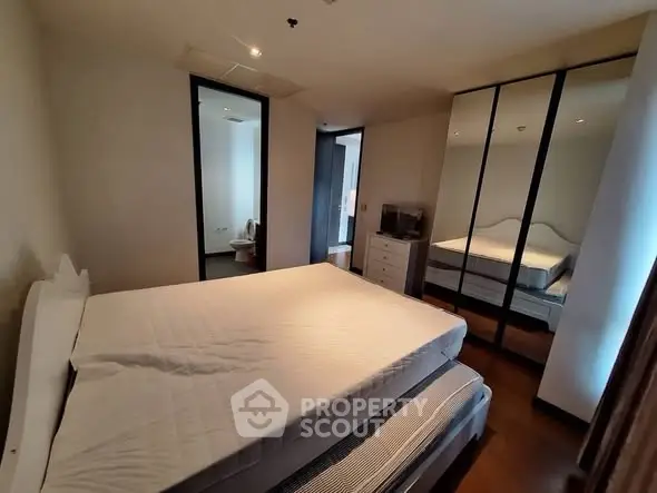 Spacious bedroom with mirrored wardrobe and modern decor