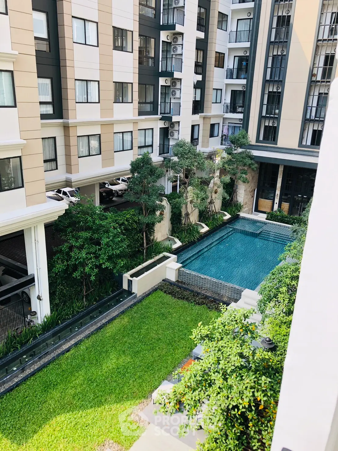 Modern apartment complex with pool and lush garden view