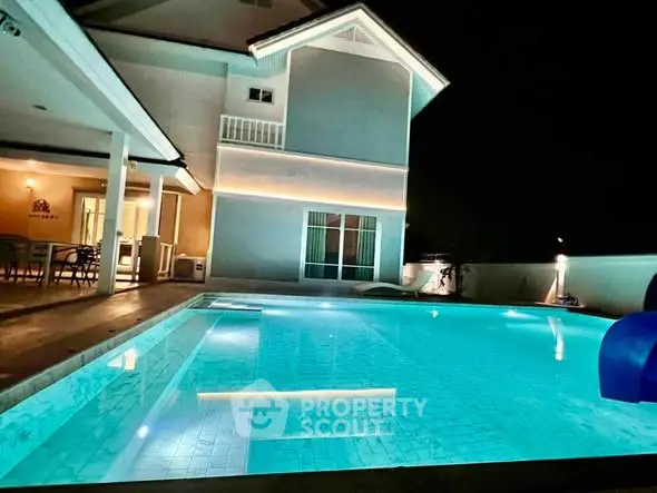 Luxurious night view of a modern home with illuminated swimming pool.