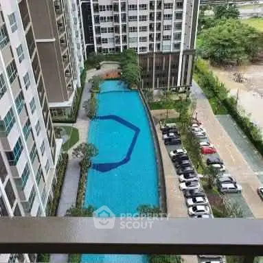 Stunning aerial view of modern apartment complex with luxurious swimming pool and lush greenery.