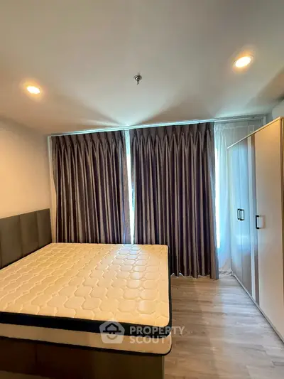 Modern bedroom with large window and elegant curtains in a stylish apartment.