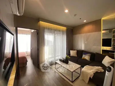 Modern living room with cozy sofa and elegant decor, connected to a bright bedroom with natural light.