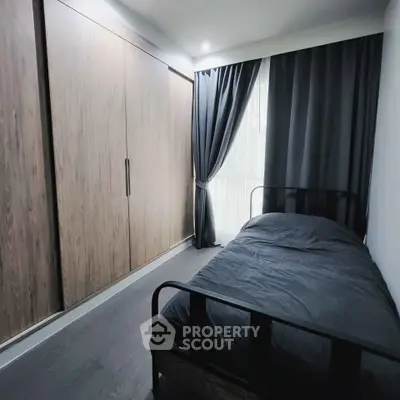 Modern bedroom with sleek wooden wardrobe and stylish black bed frame