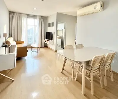 Spacious living room with modern furniture and natural light in a stylish apartment.