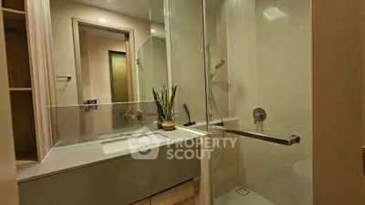 Modern bathroom with glass shower and sleek vanity in luxury apartment