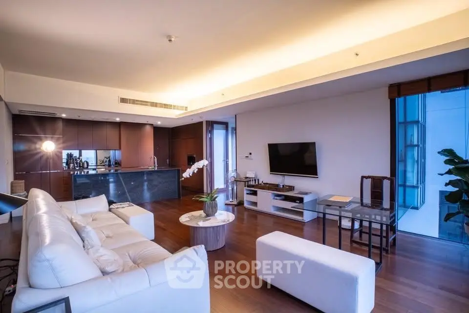 Luxurious modern living room with open kitchen, elegant decor, and ambient lighting.