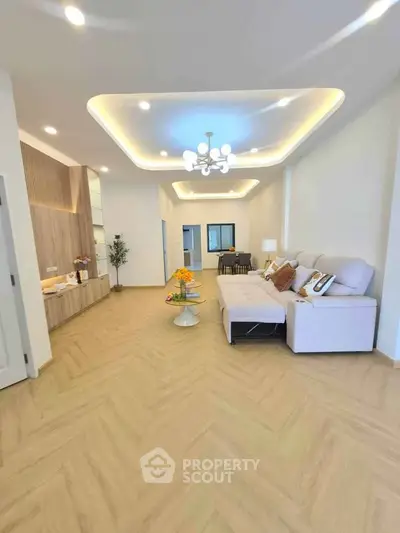 Spacious modern living room with elegant lighting and cozy seating area.