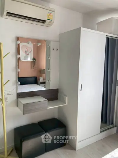 Modern bedroom with stylish vanity, wardrobe, and air conditioning unit.
