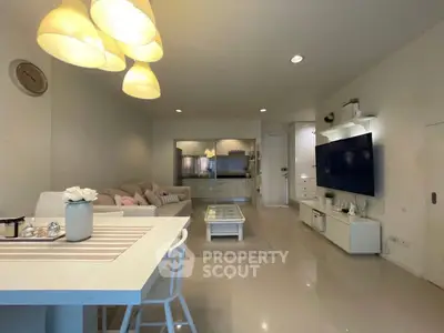 Modern living room with stylish decor and open layout, featuring a cozy seating area and sleek entertainment center.