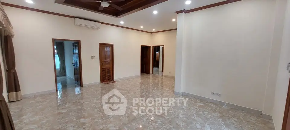 Spacious unfurnished living room with marble flooring and ceiling fan