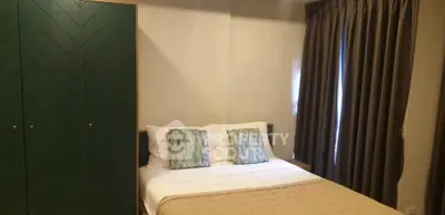 Cozy bedroom with stylish green wardrobe and elegant curtains, perfect for relaxation.