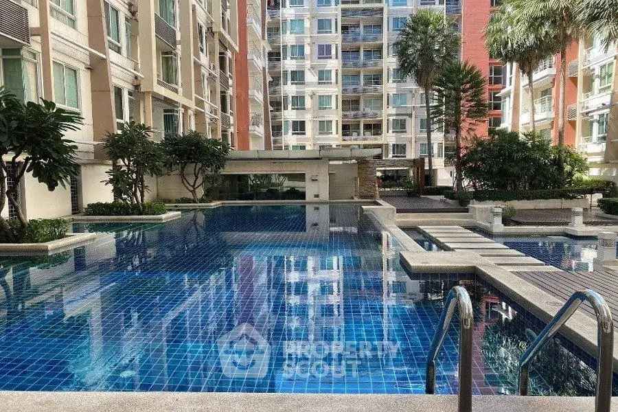 Luxurious condominium pool area with modern design and lush greenery