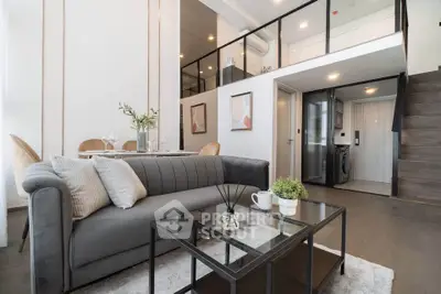 Modern loft apartment with stylish living room and mezzanine, featuring sleek furniture and open layout.