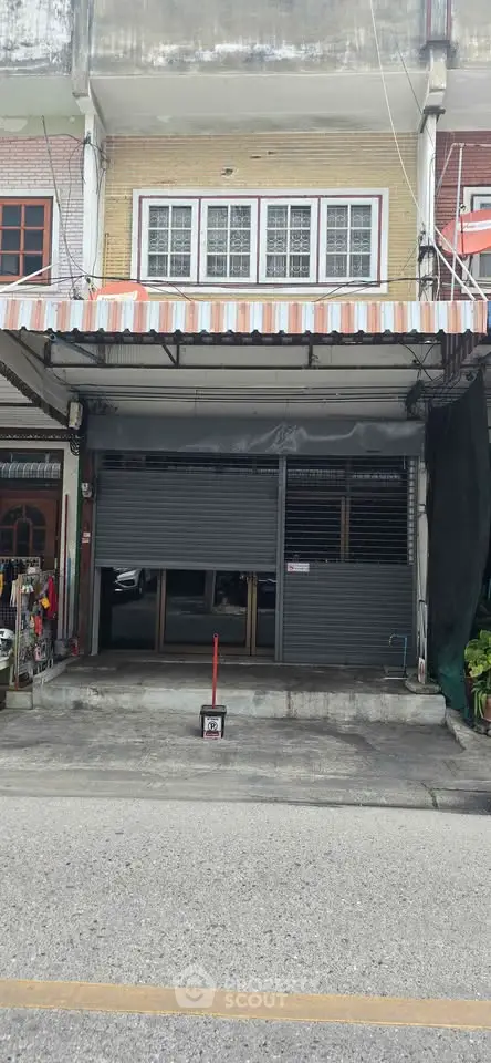 Charming commercial property with secure roller shutter and covered awning, ideal for retail or small business.