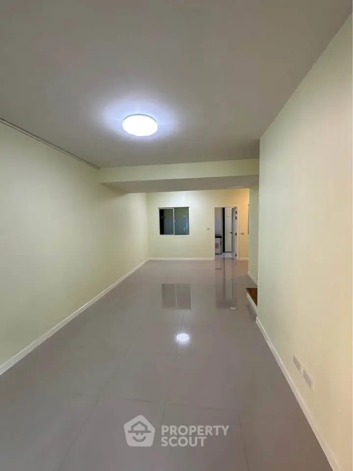 Spacious empty room with glossy tiled floor and bright lighting, ideal for customization.
