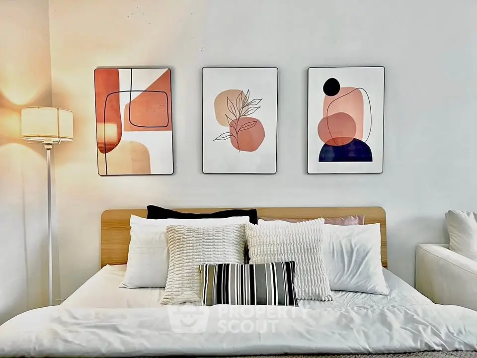 Modern bedroom with stylish decor and abstract art on the wall.