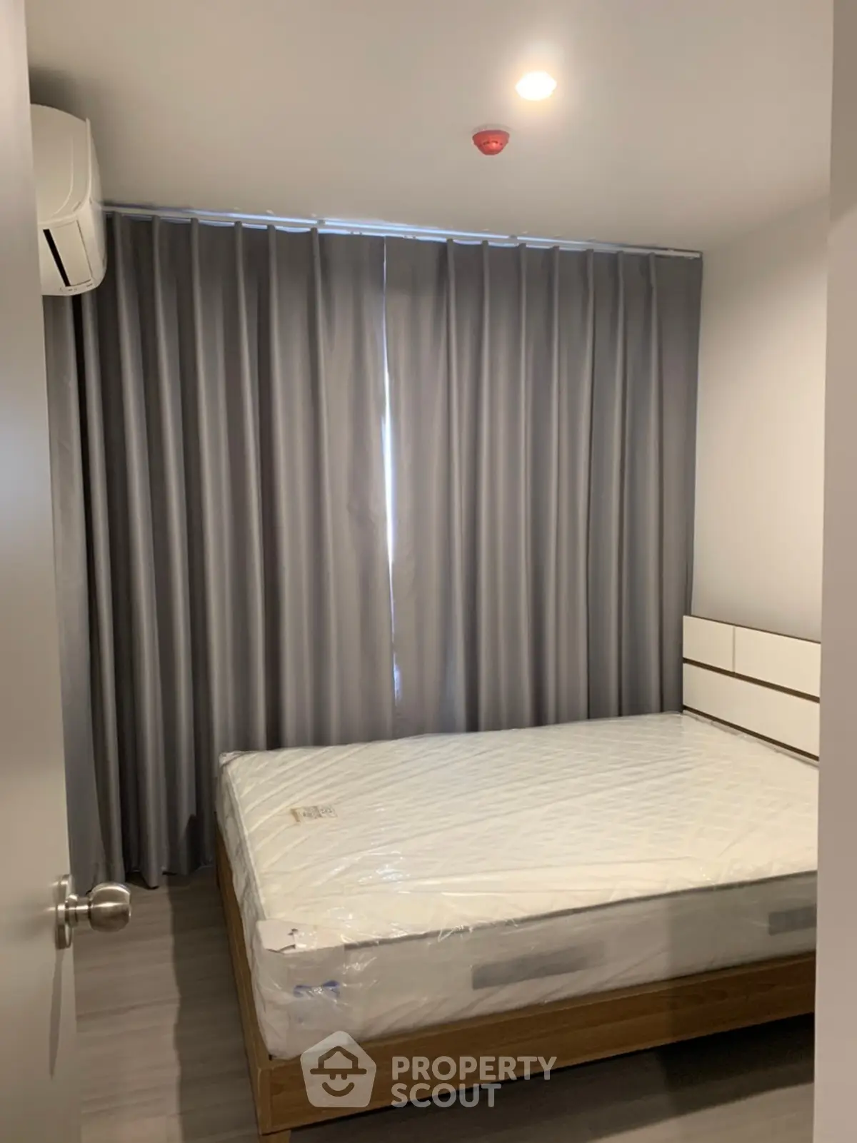 Modern bedroom with sleek design and natural light, featuring a comfortable bed and stylish curtains.