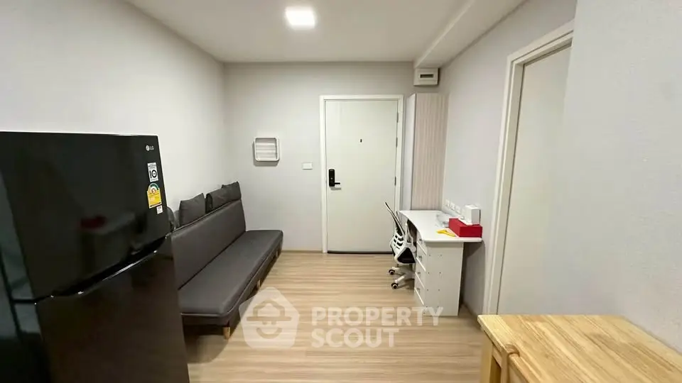 Modern apartment interior with sleek design, featuring a compact living area and workspace.