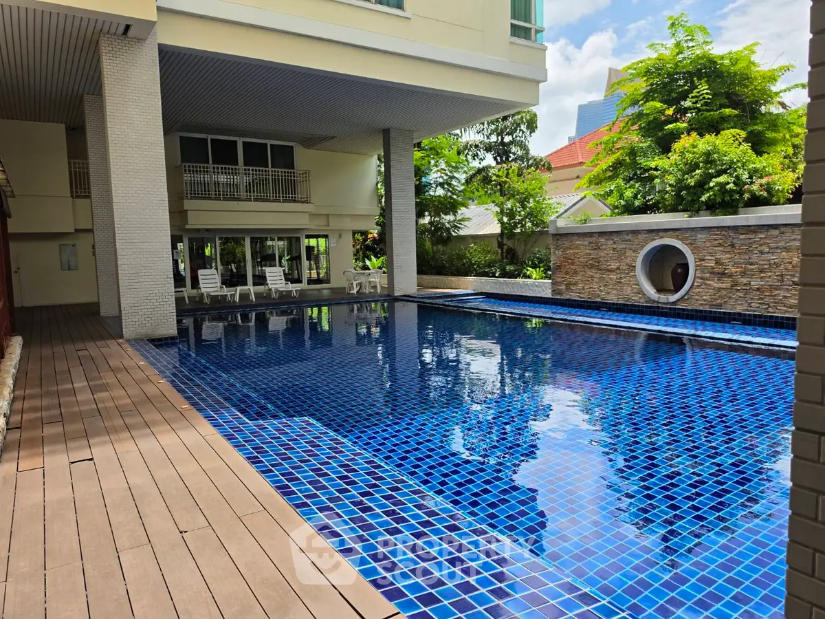 Luxurious outdoor pool area with modern design and lush greenery, perfect for relaxation and leisure.