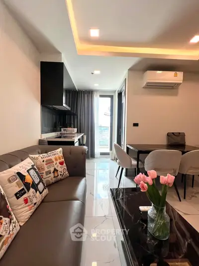 Modern living room with stylish decor and open layout, featuring a cozy sofa and elegant dining area.
