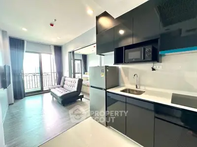 Modern open-plan apartment with sleek kitchen and balcony view